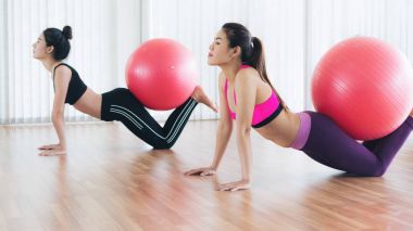 Beden eğitimi dersinde uygun topu ile egzersiz yaparak kadınlar