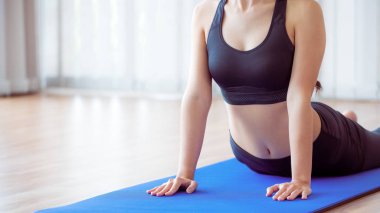 Genç kadın yoga mat kapalı spor salonunda egzersiz