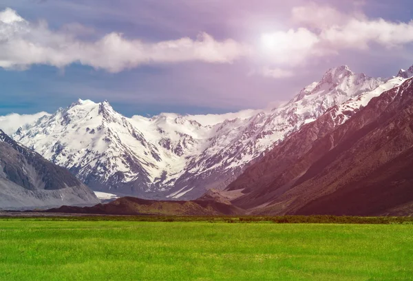 Bergketens en groen gras veld landschap — Stockfoto