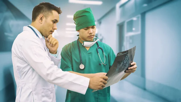Médico e cirurgião a olhar para o filme de raios-X — Fotografia de Stock