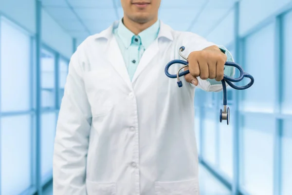 Médico varón sosteniendo estetoscopio en el hospital — Foto de Stock
