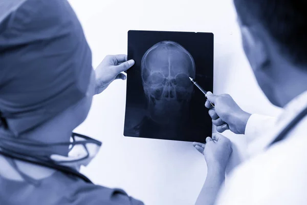 Lekarze, patrząc na RTG głowy pacjenta — Zdjęcie stockowe