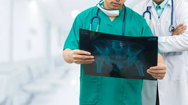 Chirurgo e medico guardando la pellicola a raggi X . — Foto Stock