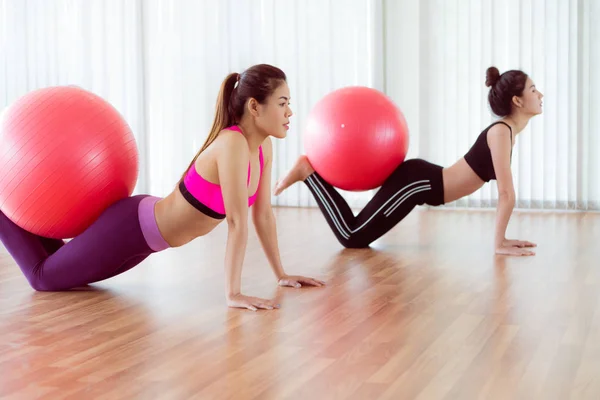 Mujeres haciendo ejercicio con la pelota en forma en la clase de gimnasia —  Fotos de Stock