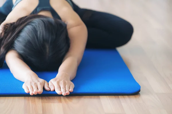Vrouw praktizerende yoga vormen in sportschool — Stockfoto