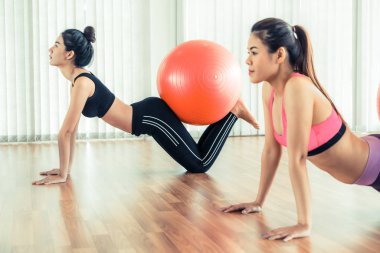 Beden eğitimi dersinde uygun topu ile egzersiz yaparak kadınlar