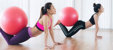 Beden eğitimi dersinde uygun topu ile egzersiz yaparak kadınlar