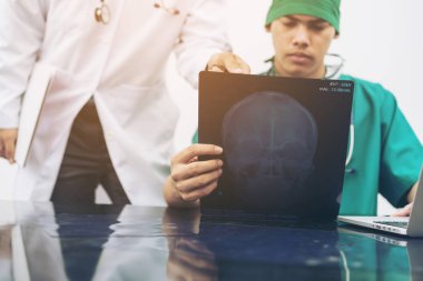 Doktorlar hastanın başına röntgen filmine bakarken