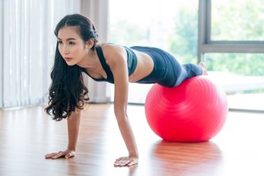 Kadın fitness salonunda uygun topu ile yapıyor