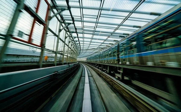 Comboio em movimento na cidade ferroviária com borrão de movimento — Fotografia de Stock
