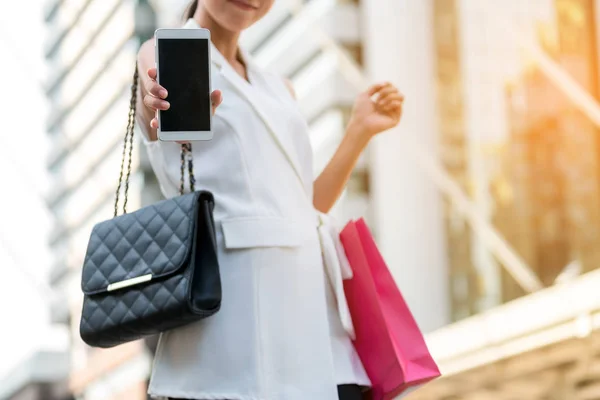 Женщина с сумкой показывает экран телефона . — стоковое фото