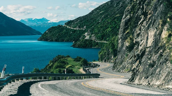 Winding Road along Mountain Cliff and Lake