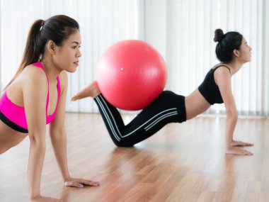 Beden eğitimi dersinde uygun topu ile egzersiz yaparak kadınlar