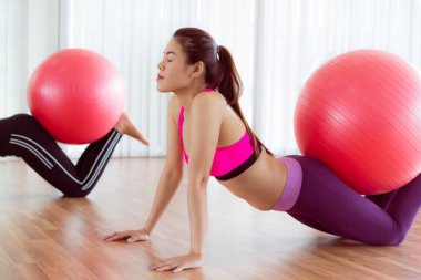 Beden eğitimi dersinde uygun topu ile egzersiz yaparak kadınlar