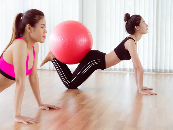 Mujeres haciendo ejercicio con la pelota en forma en la clase de gimnasia —  Fotos de Stock