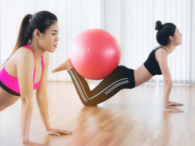 Beden eğitimi dersinde uygun topu ile egzersiz yaparak kadınlar