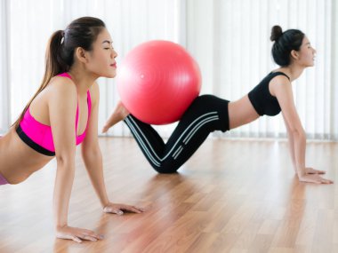 Beden eğitimi dersinde uygun topu ile egzersiz yaparak kadınlar