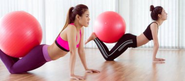 Beden eğitimi dersinde uygun topu ile egzersiz yaparak kadınlar