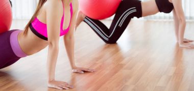 Beden eğitimi dersinde uygun topu ile egzersiz yaparak kadınlar