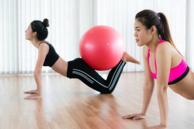 Beden eğitimi dersinde uygun topu ile egzersiz yaparak kadınlar