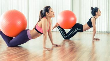 Beden eğitimi dersinde uygun topu ile egzersiz yaparak kadınlar