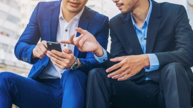 İki iş adamları iş ilişkisi cep telefonu üzerinde tartışmak.