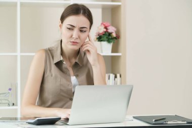 Kadın düşünüyor ve çalışma office gergin hissediyor.