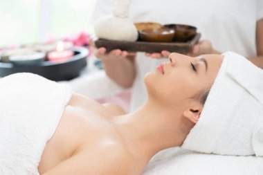 Spa yatakta rahat kadın. Terapist arka planda.