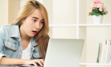 Sevimli kadın bilgisayarına bakarken heyecanlı hisseder