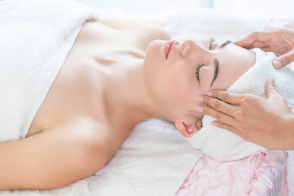 Mulher recebe massagem facial e na cabeça no spa de luxo. — Fotografia de Stock