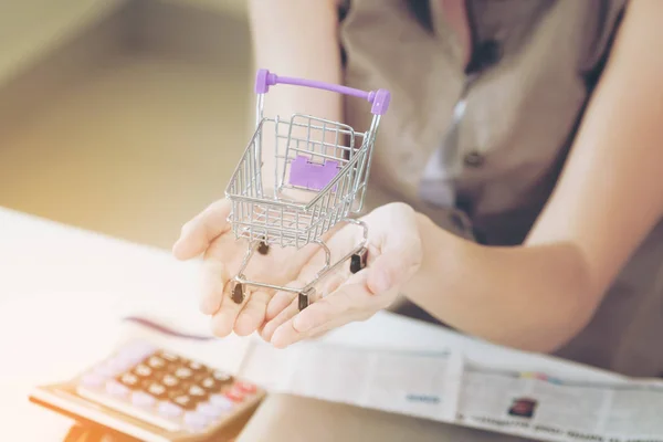 Woman holding a small shopping trolley. — Stock Photo, Image