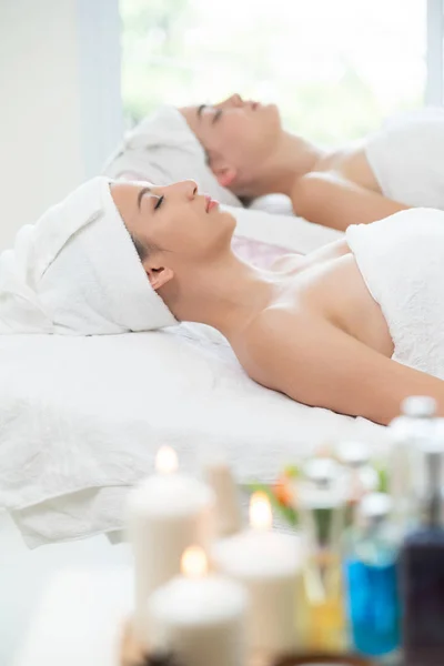 Relaxado jovem deitado na cama de spa para massagem. — Fotografia de Stock