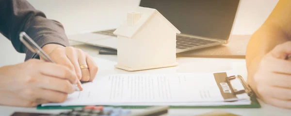 Клиент подписывает документ на покупку дома и недвижимости — стоковое фото