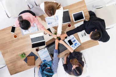 Takım çalışması çalışanları toplantıda el ele tutuşuyor.