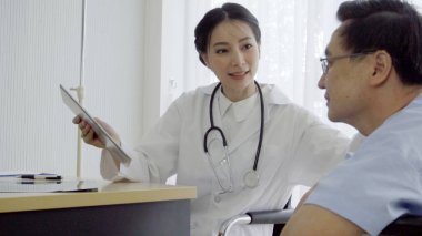 Doktor ya da hekim, hastanedeki ya da klinikteki hasta ile ilgilenir. Mutlu hasta doktoru ziyaret eder ve hastalığın tedavisi hakkında konuşur. Tıbbi sağlık ve doktor hizmeti kavramı.