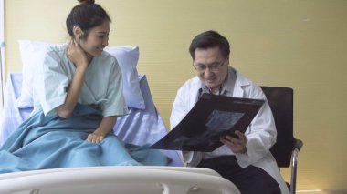 Doktor ya da hekim, hastanedeki ya da klinikteki hasta ile ilgilenir. Mutlu hasta doktoru ziyaret eder ve hastalığın tedavisi hakkında konuşur. Tıbbi sağlık ve doktor hizmeti kavramı.