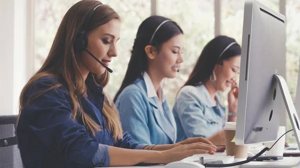 stock image Customer support agent or call center with headset works on desktop computer while supporting the customer on phone call. Operator service business representative concept.