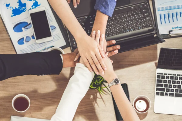 Teamwork business people join hands in meeting.