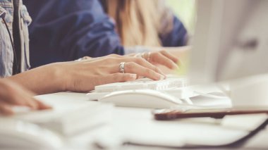 İş kadını el yazısını ve ofis masasındaki masaüstü bilgisayarını yakından çek. İş iletişimi ve işyeri kavramı.