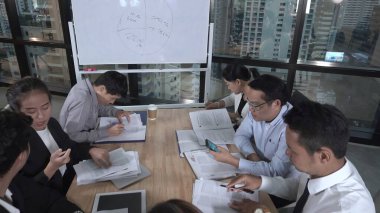 Asyalı iş adamları modern ofiste grup toplantısında pazarlama stratejisini tartıştılar.