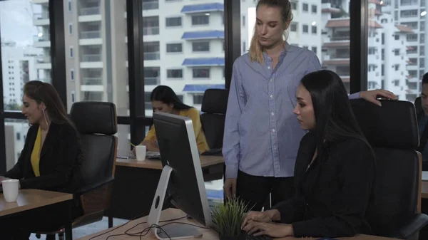 Young leader gives advice to young woman worker in modern office. Leadership and training concept.;Young leader gives advice to young woman worker in modern office. Leadership and training concept.