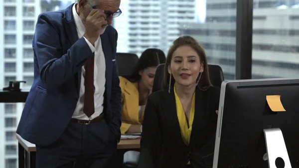 Senior manager gives advice to young woman worker in modern office. Leadership and training concept.;Senior manager gives advice to young woman worker in modern office. Leadership and training concept.