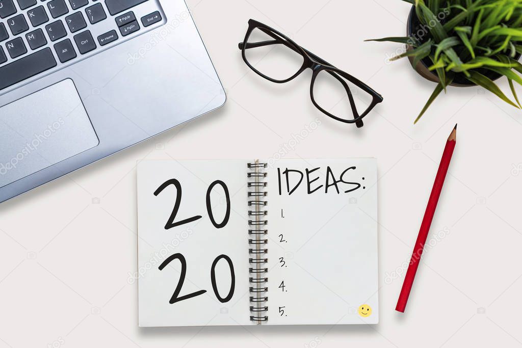 New Year Resolution Goal List 2020 - Business office desk with notebook written in handwriting about plan listing of new year goals and resolutions setting. Change and determination concept.