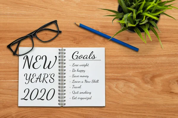 写字台写满了笔记本 上面写着新年目标和决心的计划清单 — 图库照片
