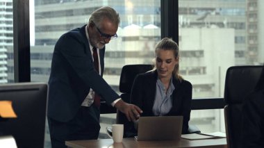 Üst düzey yönetici modern ofisteki genç kadın çalışana tavsiyelerde bulunuyor. Liderlik ve eğitim konsepti. ; Modern ofisteki genç kadın çalışana kıdemli yönetici tavsiyelerde bulunur. Liderlik ve eğitim kavramı.