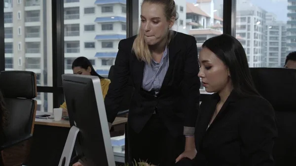 Young leader gives advice to young woman worker in modern office. Leadership and training concept.;Young leader gives advice to young woman worker in modern office. Leadership and training concept.