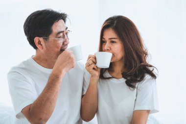 Mutlu Asyalı son sınıf çifti evde iyi vakit geçiriyor. Yaşlıların emekliliği ve sağlıklı vatandaşların ihtiyarlık kavramı.