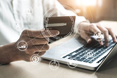 Genç adam, laptop bilgisayar başvurusu ya da web sitesinde online alışveriş yapmak için kredi kartı kullanıyor. E-ticaret ve online alışveriş kavramı.