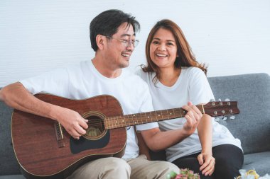 Mutlu Asyalı son sınıf çifti evde iyi vakit geçiriyor. Yaşlıların emekliliği ve sağlıklı vatandaşların ihtiyarlık kavramı.