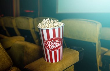Sinemada bir sıra sarı koltuk ve sandalyede patlamış mısır.